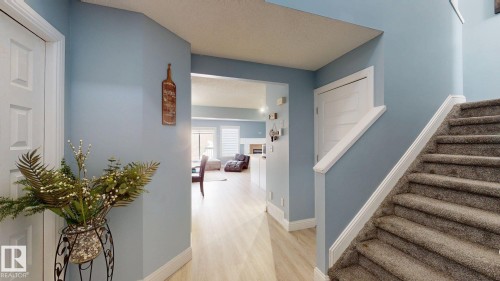 Inviting entryway featuring light-colored walls, a carpeted staircase, and wood-look flooring - 3613 11 Street, Edmonton, AB - Indoor Photo Showing Other Room