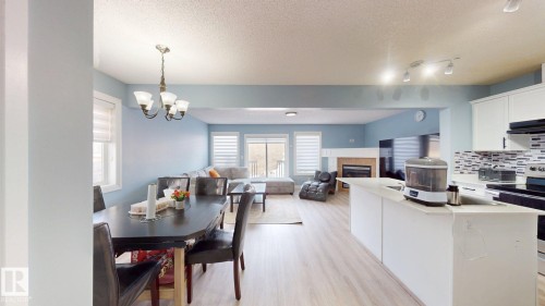 The open concept main living area features a dining space, living area, and kitchen - 3613 11 Street, Edmonton, AB - Indoor With Fireplace