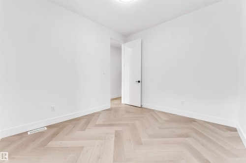 Room featuring light wood-finish herringbone flooring and crisp white walls - 4006 35 St, Beaumont, AB - Indoor Photo Showing Other Room