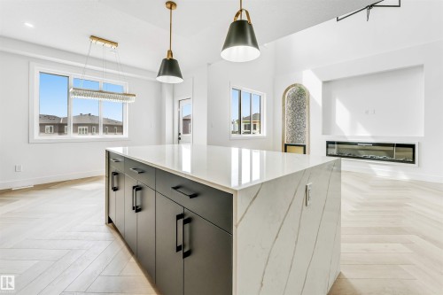 Waterfall-edge island with a quartz countertop and black cabinetry - 4006 35 St, Beaumont, AB - Indoor