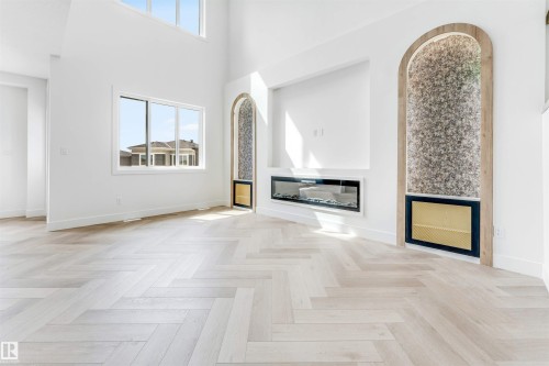 Herringbone wood-finish flooring complements the bright, open interior - 4006 35 St, Beaumont, AB - Indoor Photo Showing Other Room With Fireplace