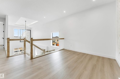 Upper-level landing featuring wood-finish flooring, glass panel railings with wood posts, and recessed lighting - 4006 35 St, Beaumont, AB - Indoor Photo Showing Other Room