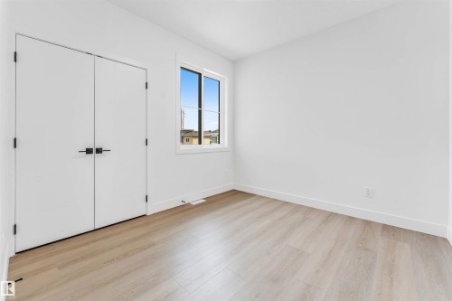 Room featuring light wood-finish flooring, white walls, and a window with white trim - 4006 35 St, Beaumont, AB - Indoor Photo Showing Other Room