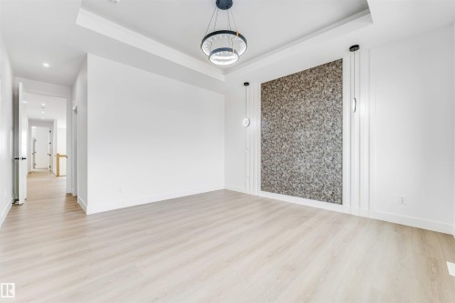 Spacious room featuring light wood-finish flooring and a tray ceiling - 4006 35 St, Beaumont, AB - Indoor Photo Showing Other Room