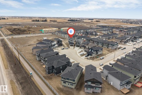 Aerial overview of a residential development featuring single-family homes and townhomes, with ongoing construction activity in the surrounding area - 4006 35 St, Beaumont, AB - Outdoor With View