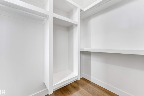 Built-in closet system featuring multiple shelves, a hanging rod, and a central storage cubby - 4006 35 St, Beaumont, AB - Indoor With Storage