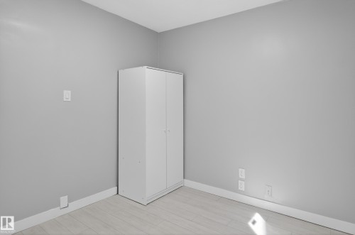 Room featuring light gray painted walls, white baseboards, and light wood-finish flooring - 8722 112 Avenue, Edmonton, AB - Indoor Photo Showing Other Room