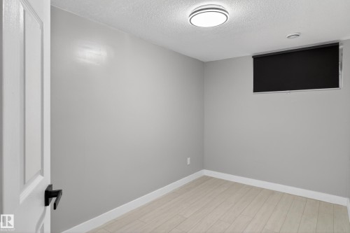 Room featuring light-toned flooring, neutral wall paint, and white baseboards - 8722 112 Avenue, Edmonton, AB - Indoor Photo Showing Other Room