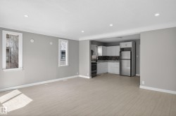 Open-concept living space featuring wood-finish flooring, recessed lighting, and a modern kitchen - 