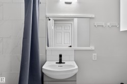 Wall-mounted pedestal sink with a matte black faucet - 