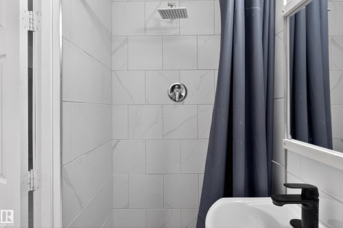 Shower with white subway tile surround, chrome fixtures, and a ceiling-mounted rainfall showerhead - 8722 112 Avenue, Edmonton, AB - Indoor Photo Showing Bathroom