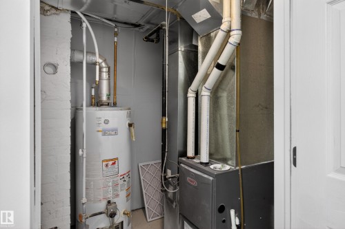Dedicated utility closet housing the water heater and HVAC system - 8722 112 Avenue, Edmonton, AB - Indoor Photo Showing Basement