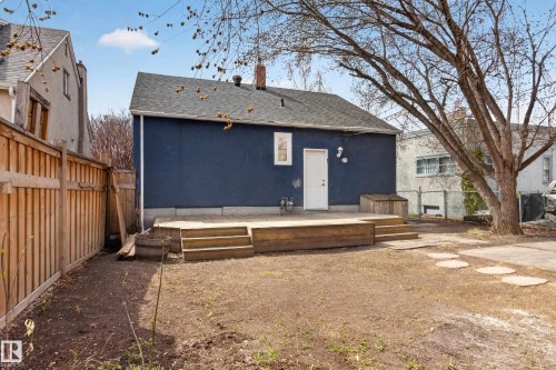 Rear exterior with a dark blue facade, a grey shingle roof, and a white exterior door - 8722 112 Avenue, Edmonton, AB - Outdoor