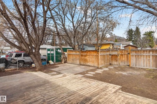 Wood-finish deck with multiple levels, featuring a private yard with wood fencing and stepping stones - 8722 112 Avenue, Edmonton, AB - Outdoor