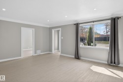Spacious interior featuring light wood-finish flooring, neutral gray walls, and white trim - 