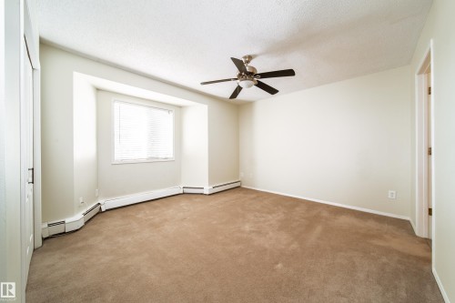 Neutral-toned carpeting throughout - 302 9138 83 Avenue, Edmonton, AB - Indoor Photo Showing Other Room