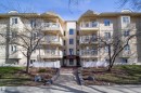 Multi-story residential building featuring a stucco facade, multiple balconies with white railings, and a central entryway - 302 9138 83 Avenue, Edmonton, AB  - Outdoor With Balcony With Facade 