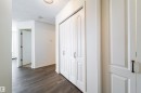Entryway featuring wood-finish flooring, white paneled doors with dark hardware, and a ceiling-mounted light fixture - 302 9138 83 Avenue, Edmonton, AB  - Indoor Photo Showing Other Room 