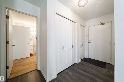 Entryway with dark wood-finish flooring, white walls, and a white entrance door - 302 9138 83 Avenue, Edmonton, AB - Indoor Photo Showing Other Room