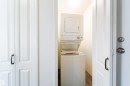 Dedicated laundry closet featuring a white stacked washer and dryer unit - 302 9138 83 Avenue, Edmonton, AB  - Indoor Photo Showing Laundry Room 