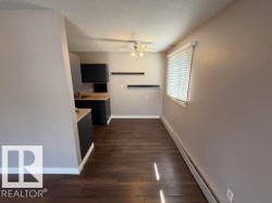 Kitchenette featuring dark cabinetry, light wood-finish countertops, and a single basin sink - 