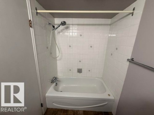 White subway tile shower surround with decorative accent tiles - 201 11324 97 Street Nw, Edmonton, AB - Indoor Photo Showing Bathroom