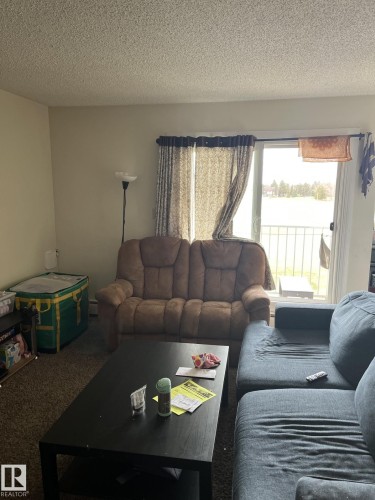 Living area with sliding glass door access to an outdoor balcony - 68 11265 31 Avenue, Edmonton, AB - Indoor Photo Showing Living Room