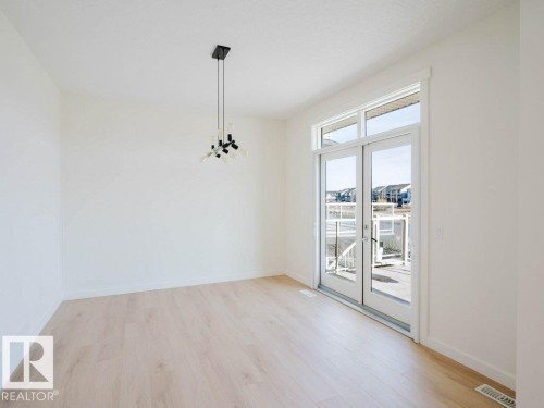 Spacious room with light wood-finish flooring - 15867 11 Avenue, Edmonton, AB - Indoor Photo Showing Other Room