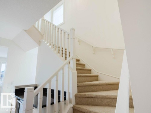 Carpeted staircase with white painted balusters and handrail - 15867 11 Avenue, Edmonton, AB - Indoor Photo Showing Other Room