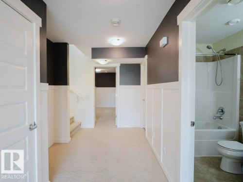 Hallway featuring neutral carpet flooring and white wainscoting - 15867 11 Avenue, Edmonton, AB - Indoor Photo Showing Bathroom