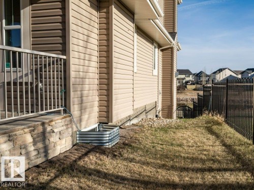 Exterior siding in a neutral tone with a contrasting stone veneer foundation - 15867 11 Avenue, Edmonton, AB - Outdoor