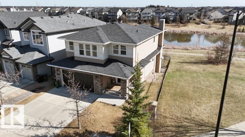 Two-story residence featuring a stone and stucco exterior, an attached two-car garage, and a concrete driveway - 15867 11 Avenue, Edmonton, AB - Outdoor