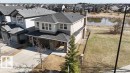 Two-story residence featuring a stone and stucco exterior, an attached two-car garage, and a concrete driveway - 15867 11 Avenue, Edmonton, AB  - Outdoor 