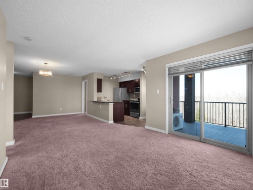 Open-concept living area featuring plush carpeting, neutral wall tones, and recessed lighting - 417 1060 Mcconachie Boulevard, Edmonton, AB - Indoor
