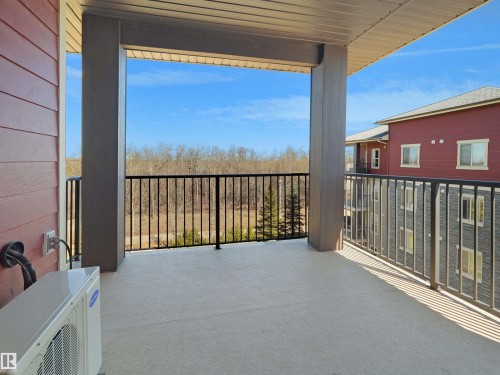Spacious covered balcony with a concrete surface and black metal railings - 417 1060 Mcconachie Boulevard, Edmonton, AB - Outdoor With Balcony With Exterior