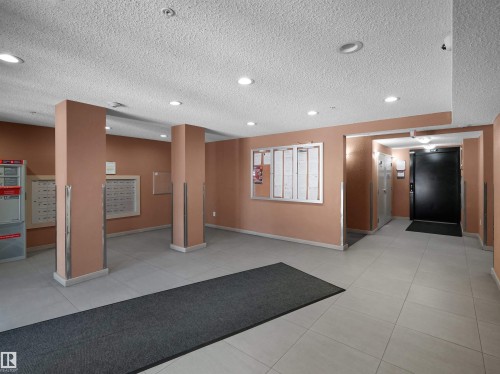 Main lobby area featuring light-toned tile flooring, recessed ceiling lighting, and warm-toned wall finishes - 417 1060 Mcconachie Boulevard, Edmonton, AB - Indoor