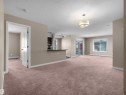 Open-concept living area featuring plush carpeting, neutral wall tones, and a drum-shaped ceiling light fixture - 417 1060 Mcconachie Boulevard, Edmonton, AB  - Indoor Photo Showing Other Room 