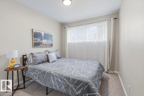 Neutral wall paint in a bedroom featuring a window with sheer and blackout curtains - 13107 133 Street, Edmonton, AB - Indoor Photo Showing Bedroom