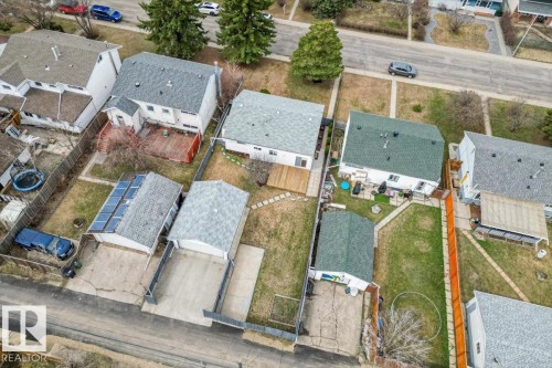 Aerial view of residential properties featuring multiple detached garages, fenced yards, and a variety of roofing materials including asphalt shingles and solar panels - 13107 133 Street, Edmonton, AB - Outdoor With Deck Patio Veranda