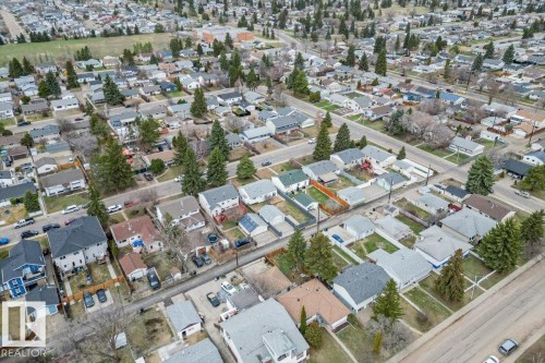 Aerial overview of a residential neighborhood featuring detached single-family homes, mature trees, paved streets, and a uniform grid layout - 13107 133 Street, Edmonton, AB - 