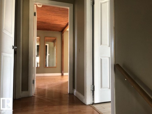 Hallway featuring wood-finish flooring, a paneled wood ceiling, and built-in wall mirrors - 11507 141 Avenue, Edmonton, AB - Indoor Photo Showing Other Room