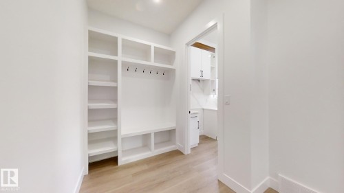 Mudroom featuring built-in white cabinetry, integrated shelving, and bench seating with storage - 1707 18 Street Nw, Edmonton, AB - Indoor