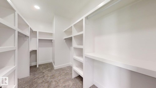 Walk-in closet featuring built-in shelving, ample hanging rods, and recessed lighting - 1707 18 Street Nw, Edmonton, AB - Indoor With Storage