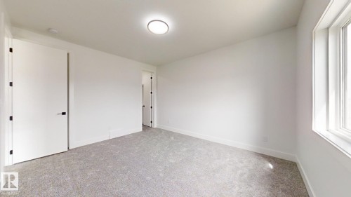 Spacious room featuring light gray carpet flooring, white walls, and bright overhead lighting - 1707 18 Street Nw, Edmonton, AB - Indoor Photo Showing Other Room
