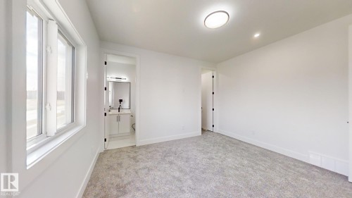 Room featuring light grey carpeting, white walls, and a large window with white trim - 1707 18 Street Nw, Edmonton, AB - Indoor Photo Showing Other Room