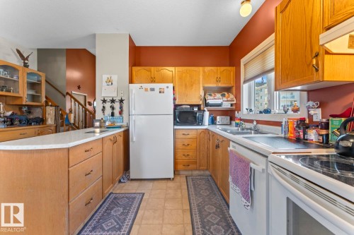 Kitchen featuring wood cabinetry, laminate countertops, and tile flooring - 1414 7 Avenue, Cold Lake, AB - Indoor Photo Showing Kitchen With Double Sink