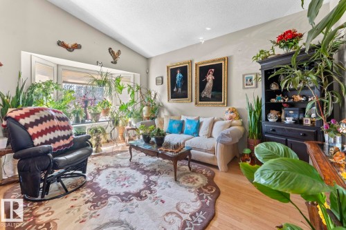 Vaulted ceiling living room featuring a wide bay window, recessed lighting, wood-finish flooring, and a decorative area rug - 1414 7 Avenue, Cold Lake, AB - Indoor