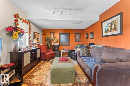 Living room featuring orange accent walls and a neutral ceiling - 1414 7 Avenue, Cold Lake, AB - Indoor Photo Showing Living Room
