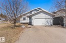 Light gray siding exterior with a white garage door, front entry, and a paved driveway - 1414 7 Avenue, Cold Lake, AB  - Outdoor 