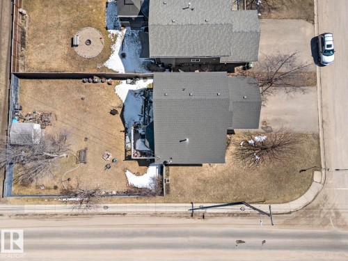 Property featuring a gray shingled roof, a fenced backyard, and a paved street frontage with sidewalk - 1414 7 Avenue, Cold Lake, AB - 